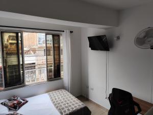 a bedroom with a bed and a tv on the wall at Edificio Wil Hostal Apt 201 in Cali