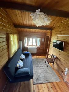 a living room with a black couch in a log cabin at Entrerrobles in Valdeavellano de Tera