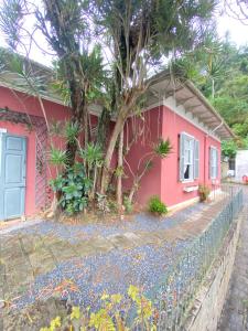 a pink house with a tree in front of it at Villa Aruanda in Petrópolis