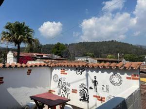a white wall with drawings on it with a table on it at Cristales de Antigua Hotel Cristal in Antigua Guatemala