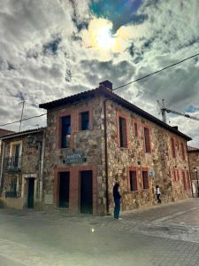 a person standing in front of a stone building at Martín Taberna in Villavieja del Lozoya