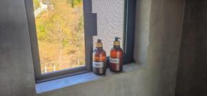 Zwei Flaschen stehen auf einer Fensterbank. in der Unterkunft Parcela in Mazunte + 7 Fotos