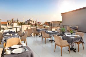 a restaurant with tables and chairs on a balcony at Great Fortune Concept Hotel in Istanbul