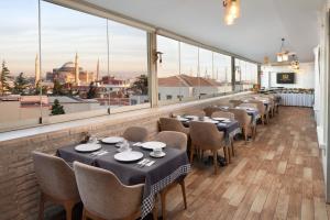a row of tables and chairs in a room with windows at Great Fortune Concept Hotel in Istanbul