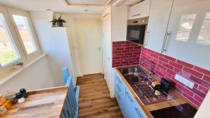a kitchen with a sink and a red brick wall at Studio De Gravin in Gouda