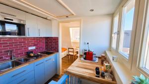 a kitchen with blue cabinets and a red brick wall at Studio De Gravin in Gouda