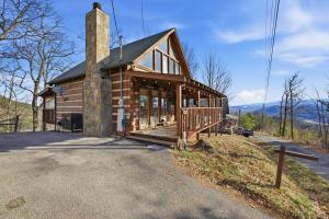 a log cabin with a porch and a chimney at Somewhere In Time cabin in Sevierville