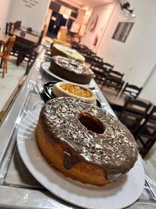 three donuts on a tray on a table at Pousada Akuto's in Aparecida