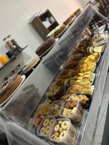 a display case filled with lots of different types of pastries at Pousada Akuto's in Aparecida