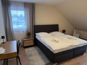 a bedroom with a bed and a table and a window at Pensione Ristorante Moretti in Nitra
