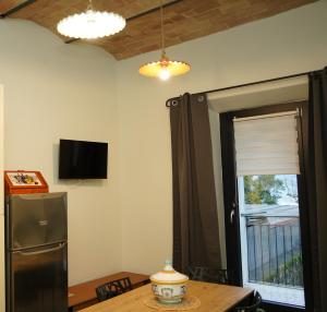 a kitchen with a refrigerator and a table and a window at Civico 95 Alloggio Turistico in Marta