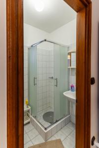 a glass shower in a bathroom with a sink at Kispál Apartmanház in Zalakaros