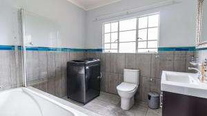 ein Badezimmer mit Badewanne, Toilette und Waschbecken in der Unterkunft Cottage Protea in Doornrandjies + 15 Fotos
