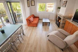 a living room with a couch a chair and a fireplace at Pool and sea 20' from Barcelona in Premiá de Mar
