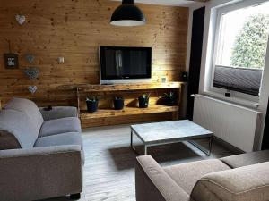 a living room with two couches and a flat screen tv at Apartamenty 5 i 6 w Karkonoszach in Jelenia Góra