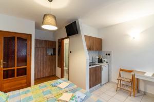 a bedroom with a bed and a kitchen with a table at Kispál Apartmanház in Zalakaros +19 photos