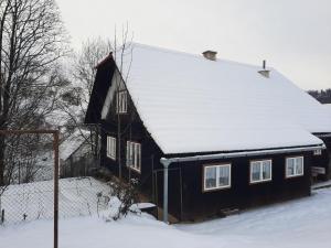 a house with snow on the roof of it at Chalupa u Josefa in Valašská Polanka