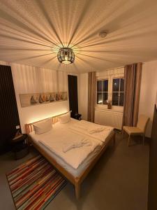 a bedroom with a large bed and a chandelier at Störtebekers Kuschelnest -265 in Sagard