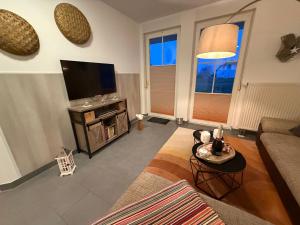 a living room with a couch and a television at Störtebekers Kuschelnest -265 in Sagard