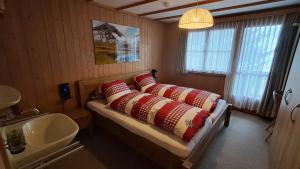 a bedroom with a bed with pillows and a sink at Chalet Suveran 1 in Arosa