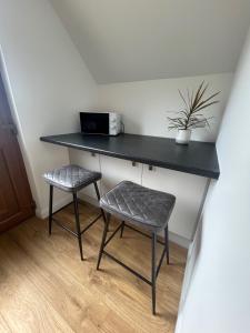 a black desk with a chair and a plant at The Studio at Torr Leathann - Modern Studio in Stittenham