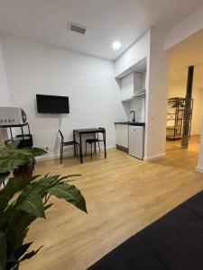 a living room with a table and a kitchen at Apartamentos Melisa - Madrid in Madrid
