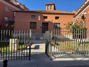 a fence in front of a brick building at Apartamentos Melisa - Madrid in Madrid