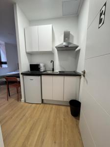 a kitchen with white cabinets and a counter top at Apartamentos Melisa - Madrid in Madrid +3 photos