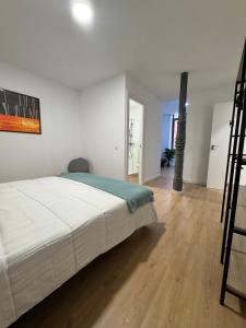 a bedroom with a white bed and a wooden floor at Apartamentos Melisa - Madrid in Madrid