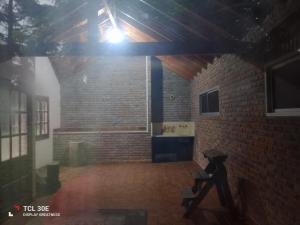 a room with a brick wall and a table and a light at Quinta Atalaya in General Rodríguez