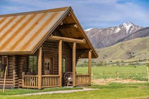 a log cabin with mountains in the background at Copper Rose Ranch in Livingston
