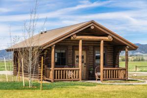 a log cabin with a porch and a deck at Copper Rose Ranch in Livingston