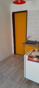 a kitchen with a yellow door and a wooden floor at Cabañas Jardín del Neuquén in Huinganco