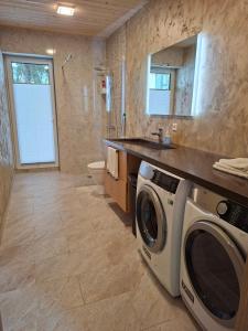 a bathroom with a washer and dryer at Puhkemaja Pühajärvel in Otepää