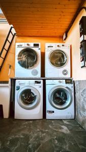 two washing machines and a washer and dryer in a room at Albergue Lecer Sobrado in Porta