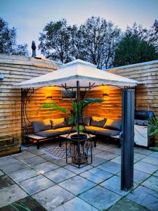 a white umbrella sitting on top of a patio at Chalet Timber -close to the woods in Anloo
