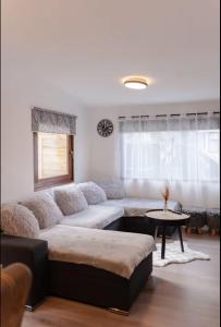 a living room with a couch and a table at Chalet Timber -close to the woods in Anloo