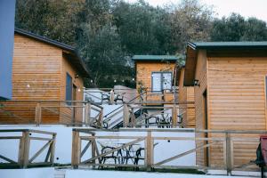 a resort cabin with a deck and chairs in the snow at Berat Hill Cabins in Berat