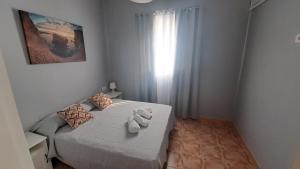 a bedroom with a bed with two towels on it at Casa Naihu in La Listada