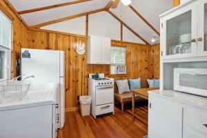 a kitchen with a white refrigerator and a table at Fish Creek Cottages in Fish Creek