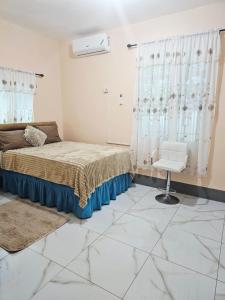a bedroom with a bed and a chair in it at Palm Breeze Villa in Green Island
