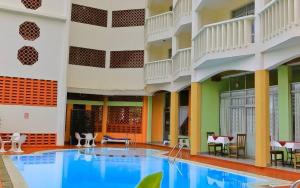 a large swimming pool in a hotel with tables and chairs at Raya Resort Nyali in Mombasa