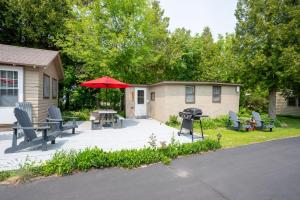 a patio with chairs and a table with an umbrella at Fish Creek Cottages in Fish Creek