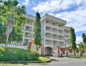 a large white building with trees in front of it at Raya Resort Nyali in Mombasa