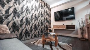 a living room with a couch and a tv on a wall at FlexHome Gemütliche Ferienwohnung in Lippstadt