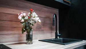 a vase of flowers sitting on a counter next to a sink at FlexHome Gemütliche Ferienwohnung in Lippstadt