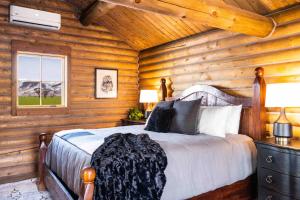 a bedroom with a bed in a log cabin at Copper Rose Ranch in Livingston