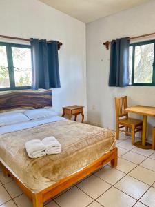 a bedroom with a bed with two towels on it at Incredible 360 views 5 min from downtown in Tepoztlán