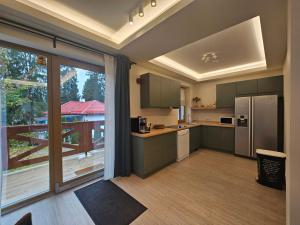 a kitchen with green cabinets and a large window at Vila Salt & Soul in Sovata