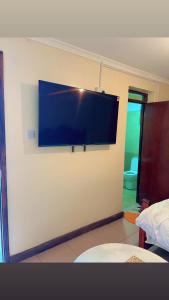 a flat screen tv on the wall of a room at GREENFIELD STUDlO DONHOLM in Nairobi